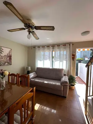 a living room with a couch and a ceiling fan at Dúplex Playa Sol Ostra in Chiclana de la Frontera