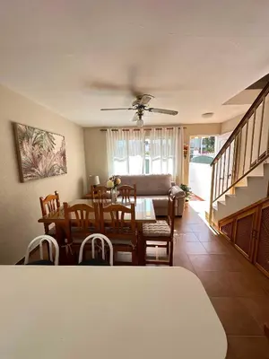 a dining room and living room with a table and chairs at Dúplex Playa Sol Ostra in Chiclana de la Frontera