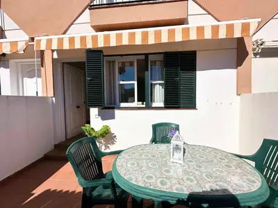 a green table and chairs on a patio at Dúplex Playa Sol Ostra in Chiclana de la Frontera