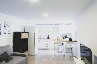 a kitchen with a refrigerator and a table and chairs at CDZ - Botica in Cádiz