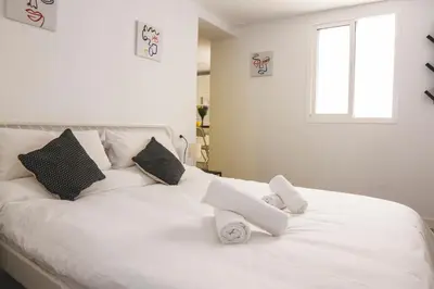 a white bed with two white towels on it at CDZ - Botica in Cádiz