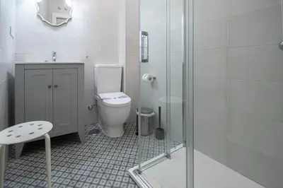 a bathroom with a toilet and a glass shower at Apartamento Las Lectoras de Cadiz in Cádiz