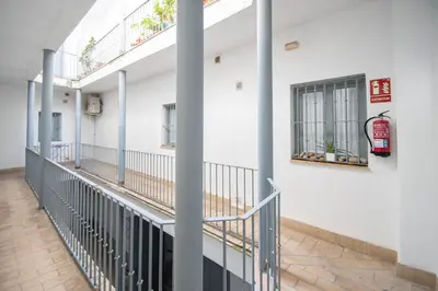 a corridor of a building with pillars and windows at Apartamento Las Lectoras de Cadiz in Cádiz