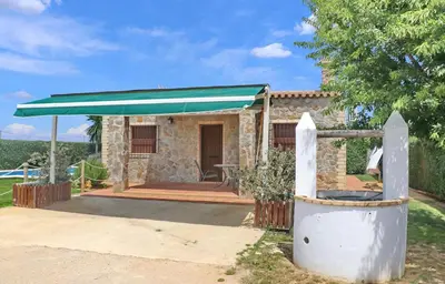 a stone house with a green awning at Chalet Piedra in Conil de la Frontera