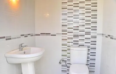 a white bathroom with a toilet and a sink at Chalet Piedra in Conil de la Frontera