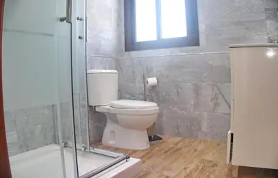 a bathroom with a toilet and a glass shower at Chalet Piedra in Conil de la Frontera