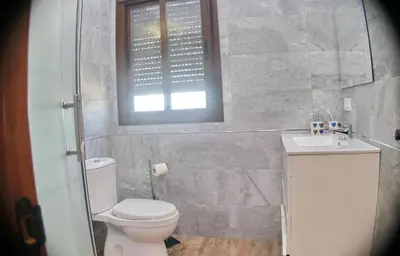 a bathroom with a toilet and a sink and a window at Chalet Piedra in Conil de la Frontera