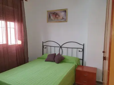 a bedroom with two beds with green sheets at Apartamento Marina de la bahía in Puerto Real