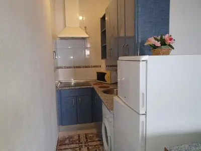 a kitchen with blue cabinets and a white refrigerator at Apartamento Marina de la bahía in Puerto Real