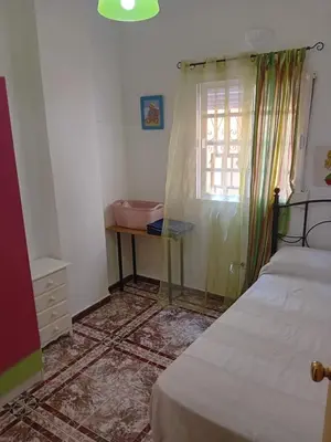 a bedroom with a bed and a table and a window at Apartamento Marina de la bahía in Puerto Real