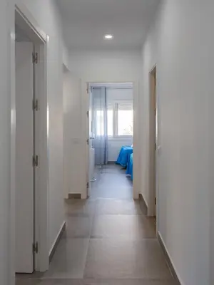 a hallway with white walls and a blue table at MAREAS Family Home by Cadiz4Rentals in Cádiz