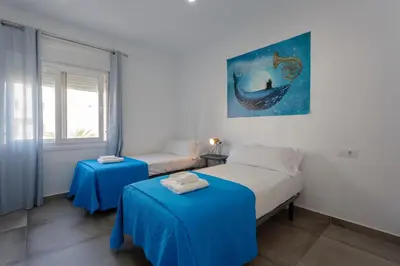 a bedroom with a bed and two tables in it at MAREAS Family Home by Cadiz4Rentals in Cádiz