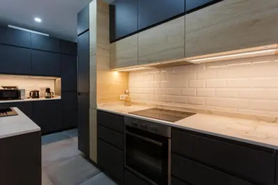 a kitchen with black cabinets and a stove at MAREAS Family Home by Cadiz4Rentals in Cádiz