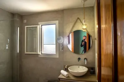 a man taking a picture of a bathroom with a sink at Valdelagrana Sunset Apartment in El Puerto de Santa María