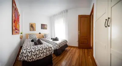 a bedroom with two beds and a window at Valdelagrana Sunset Apartment in El Puerto de Santa María
