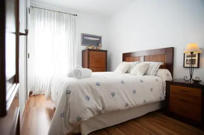 a bedroom with a large bed with a wooden headboard at Valdelagrana Sunset Apartment in El Puerto de Santa María