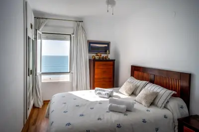 a bedroom with a bed with a view of the ocean at Valdelagrana Sunset Apartment in El Puerto de Santa María