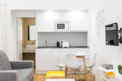a living room with a table and a kitchen at Estudio Gaviota by Cadiz Time in Cádiz