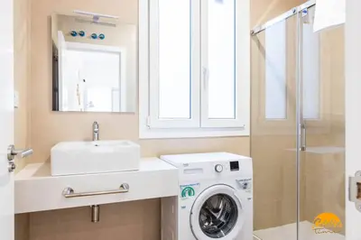 a bathroom with a washing machine and a sink at Estudio Gaviota by Cadiz Time in Cádiz