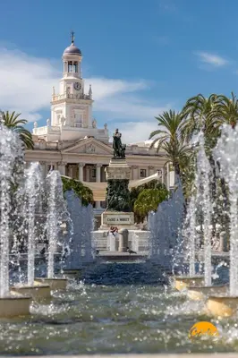 a fountain in front of a building with a clock tower at Estudio Gaviota by Cadiz Time in Cádiz