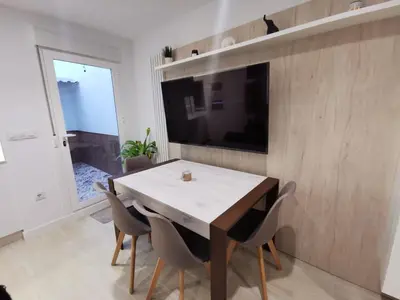 a dining room with a table and chairs and a television at Casa Viento de Levante in Cádiz