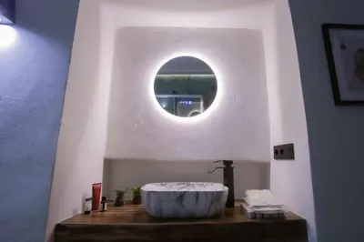 a bathroom with a large bath tub with a round mirror at Azahara Casa Boutique in Arcos de la Frontera