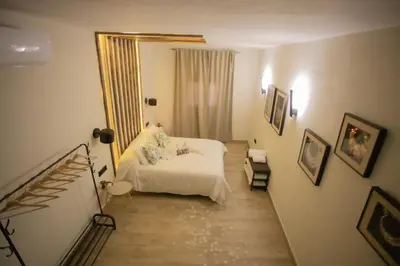a bedroom with a white bed and a mirror at Azahara Casa Boutique in Arcos de la Frontera