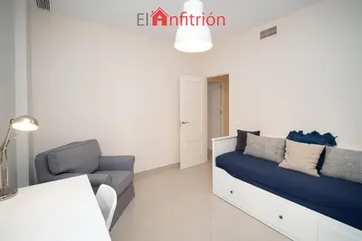 a bedroom with a bed and a couch and a table at Araucaria Home in Sanlúcar de Barrameda