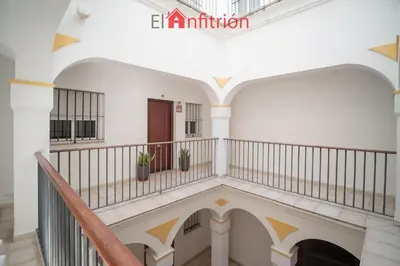 a staircase in a building with white walls and gold accents at Araucaria Home in Sanlúcar de Barrameda