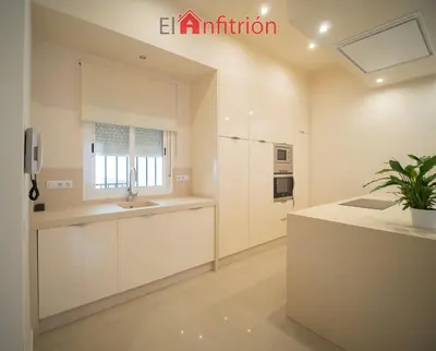 a kitchen with white cabinets and a sink at Araucaria Home in Sanlúcar de Barrameda