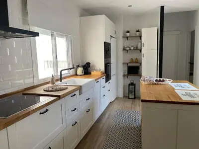 a kitchen with white cabinets and a sink and a counter at Apartamentos La Higuera 1 in Rota