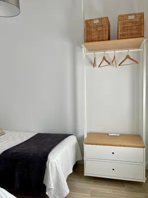 a bedroom with a bed and a shelf with baskets at Apartamentos La Higuera 1 in Rota
