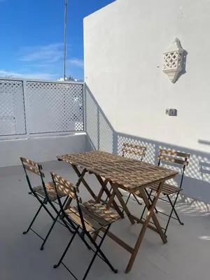 a wooden table and chairs on a balcony at Apartamentos La Higuera 1 in Rota