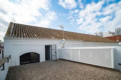 a white building with a gate and a roof at Bodega Mar - Velo de Flor in Sanlúcar de Barrameda