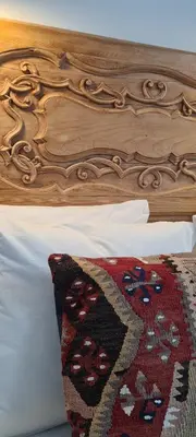 a bed with a wooden head board with a rug on it at Bodega Mar - Solera in Sanlúcar de Barrameda