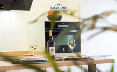 a bottle of wine and two glasses on a table at Apartamento Diego Benitez in Sanlúcar de Barrameda