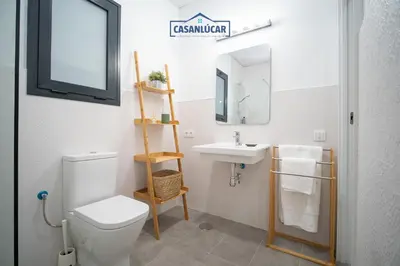 a bathroom with a toilet and a sink and a mirror at Apartamento Diego Benitez in Sanlúcar de Barrameda