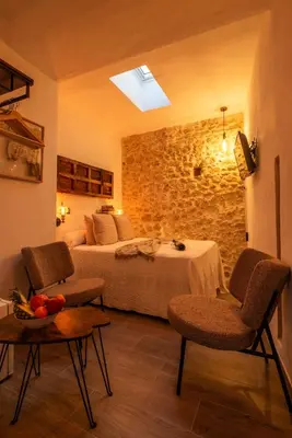 a hotel room with a bed and two chairs and a table at Alojamientos Plaza de España in Medina Sidonia