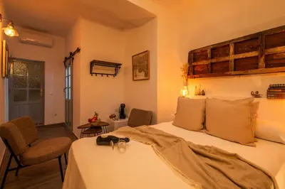 a bedroom with a bed and two chairs in it at Alojamientos Plaza de España in Medina Sidonia