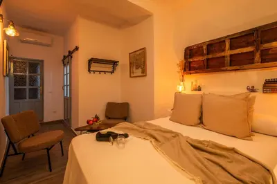 a bedroom with a bed and a chair at Alojamientos Plaza de España in Medina Sidonia