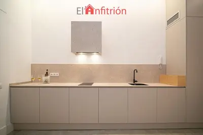 a kitchen with white cabinets and a sink at Bodega Mar - Manzanilla in Sanlúcar de Barrameda