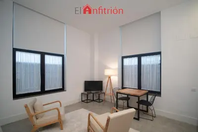 a living room with two windows and a table and chairs at Bodega Mar - Manzanilla in Sanlúcar de Barrameda
