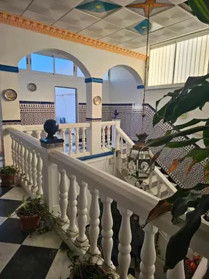 a room with a staircase with a checkerboard floor at Hostal Sevillana Costa in Chipiona