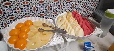 two plates of fruit and oranges on a table at Hostal Sevillana Costa in Chipiona