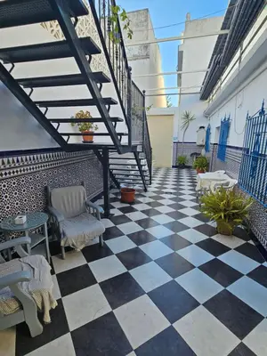 a patio with a checkered floor and stairs at Hostal Sevillana Costa in Chipiona