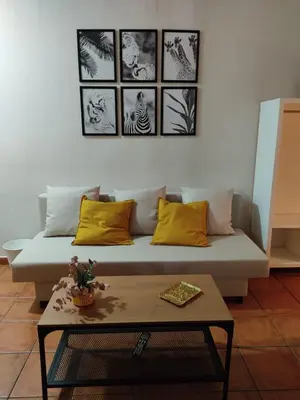 a living room with a couch and a table at ALOJAMIENTO La CAPILLITA HABITACION CON BAÑO in Sanlúcar de Barrameda