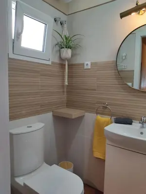 a bathroom with a toilet and a sink and a mirror at ALOJAMIENTO La CAPILLITA HABITACION CON BAÑO in Sanlúcar de Barrameda