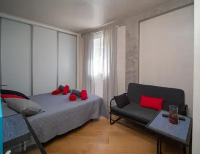a bedroom with a bed and a couch with red pillows at Sunflowers in Sanlúcar de Barrameda