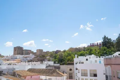 a view of a city with a castle in the background at Sunflowers in Sanlúcar de Barrameda
