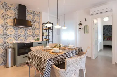 a kitchen and dining room with a table and chairs at Sol de Sanlúcar Ático centro Parking incluido in Sanlúcar de Barrameda
